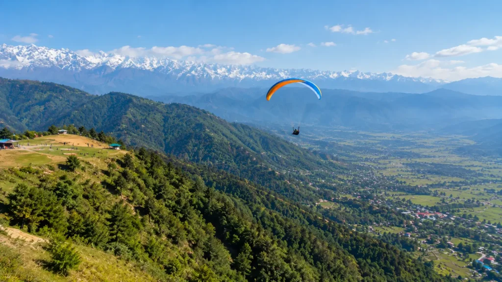 Paraglider flying above the mountain terrain between Billing and Bir in Himachal Pradesh